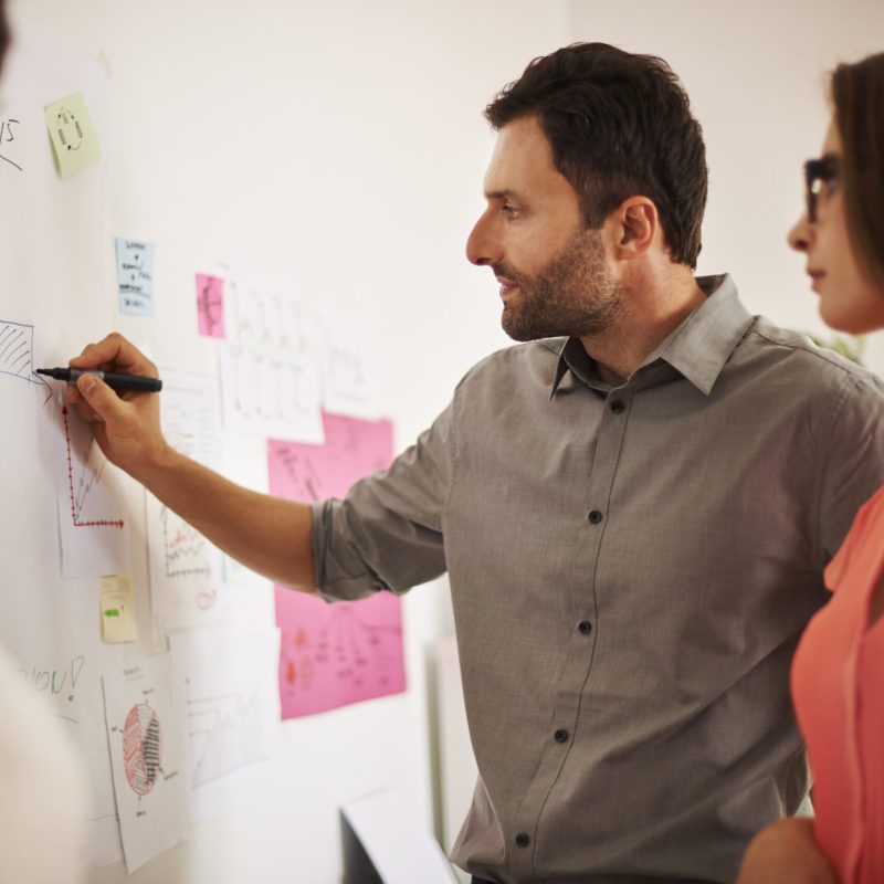Executive writing down some data on the board